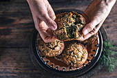 Persons hands wth corn muffins bread with leaf of chard
