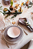 Dining table festively set in shades of grey and decorated with natural materials