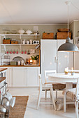 Round dining table and chairs in white, rustic kitchen