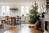 Ländliches Wohnzimmer mit Weihnachtsdekoration und geschmücktem Baum