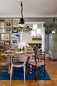 Table set for Christmas in dining room with gallery of pictures on wall