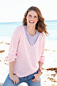 Junge Frau in lila T-Shirt und rosa Pullover