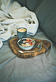 Rice coconut porridge with figs, berries and hazelnuts and cup of espresso over rustic wooden board background