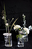 Flower arrangements in vases with perforated lids made from modelling clay