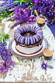 A festive blackberry cake with chocolate glaze and blue macaroons
