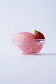 Wild strawberry sorbet in a glass bowl against a white background