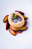A mini damson tart with puff pastry on roasted damsons