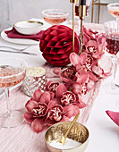 Centerpiece made of pink orchids on a festively laid table