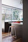 Elegant, dark fitted kitchen with breakfast bar and window front