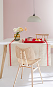 Naturfarbener Leinen-Tischläufer mit roter Bordüre auf Esstisch
