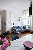 Dining table and sofa in interior with stucco frieze and panelled doors