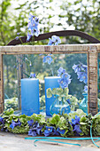 Blaue Blumen und Kerzen in Glaslaterne mit Hortensienkranz