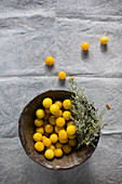 Bright yellow mirabelle plums in rustic wooden bowl on linen cloth