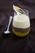 A layered dessert with passion fruit, chocolate mousse, and pineapple