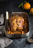 Roast chicken with oranges in a roasting pan