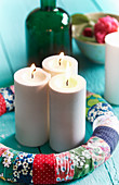 Advent wreath handmade from fabric remnants with three lit candles
