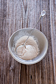 Baobab powder in a grey bowl on a wooden background