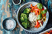 Paprikagemüse mit Knoblauch und Basilikum, Brokkoli, Quinoa und Hummus in einer Schale