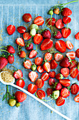 Frische Erdbeeren mit braunem Zucker auf Backpapier (Aufsicht)