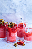 Strawberry sorbet in glasses garnished with almonds and baked strawberries