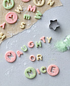 The words 'Naughty or Nice' cut out of colourful pastry