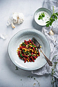 Beetroot orzo pasta with chickpeas, spinach and herb sauce (vegan)