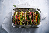 Bunt belegte vegane Vollkorn-Sandwiches mit Mandelkäse in einer Brotdose