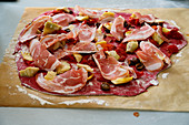 Beetroot pizza dough topped with artichokes and ham