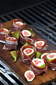 Fresh figs wrapped in pancetta on a grill
