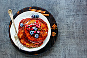 Spiced homemade pancakes with berries and honey