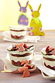 Layered raspberry and mascarpone sponge cake in jars with marzipan bunnies