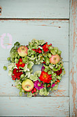 Late-summer wreath of hops, green hydrangeas, zinnias and apples