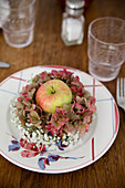 Apple in wreath of hydrangeas and gypsophila decorating plate