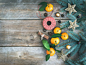 Weihnachtsdekoration mit Tannenzweigen, Mandarinen, Küchengarn und Gewürzen