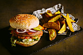 Gourmet-Burger mit Hühnerfleisch, Käse, Tomate, Kopfsalat, Zwiebel und Pommes