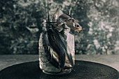 fresh anchovies, in jar with water, over black concrete plate, grunge background