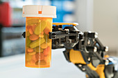 Robotic arm holding bottle of pills
