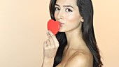 Woman kissing red heart shape