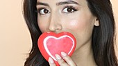 Woman kissing red heart shape