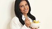 Woman eating bowl of fruit