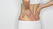 Woman rubbing painful back
