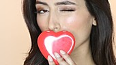 Woman kissing red heart shape