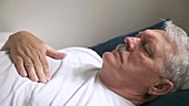 Man rubbing painful chest