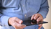 Man using tablet as finger shakes