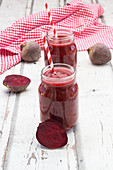 Beetroot smoothies in jars with straws
