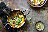 Summer minestrone soup with squash, carrot, tomatoes, basil pesto, broad bean and pasta shells