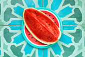 A watermelon wedge on a colourful paper plate