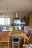 Various chairs around wooden table in rustic kitchen-dining room