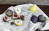 Figs, pears and pekan nuts on a white tissue on a wooden table surface