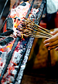 A close up of lamb satays on charcoal satay grill in Indonesia
